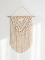 handmade macrame layered wall hanging with cotton cords and wooden dowel in boho style