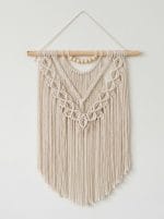 handmade macrame layered wall hanging with cotton cords and wooden dowel in boho style