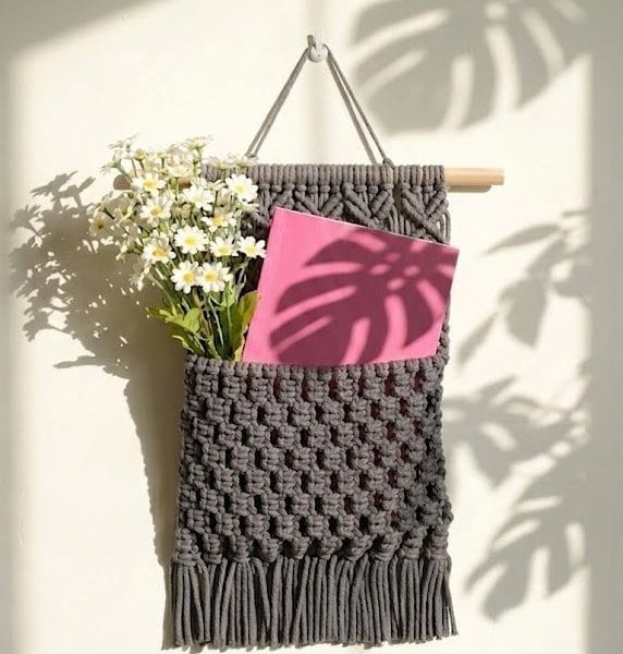 handmade macrame wall pocket organizer with woven cotton texture and boho fringe design